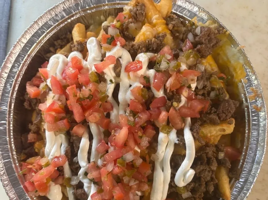 Carne asada fries loaded with cheese, pico de gallo, and sour cream