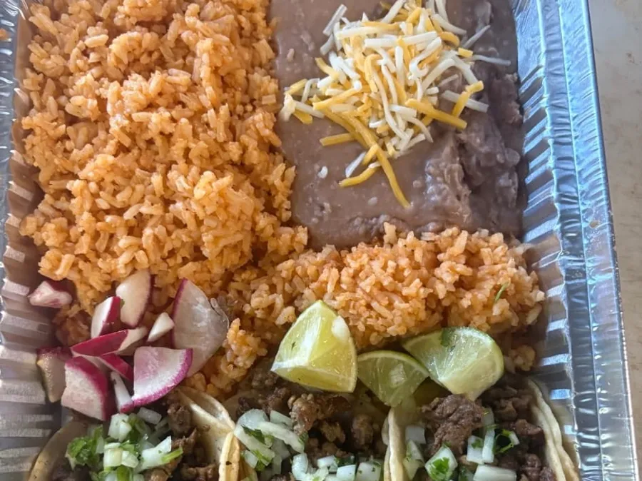 A taco plate with rice, beans, and radish