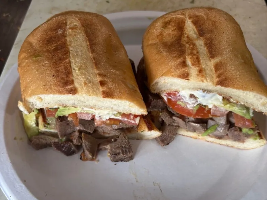 A torta sandwich with steak and avocado